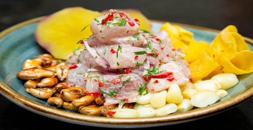 Peru's national dish is ceviche, a refreshing and flavorful seafood dish that is made by marinating raw fish in citrus juices, typically lime or lemon juice, along with onions, cilantro, and other seasonings. Ceviche is typically served cold and accompanied by an ice-cold Inca Cola. Try this pairing on a Lima city tour!