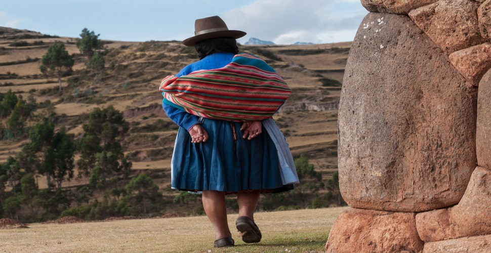 Explore ancient indigenous traditions on a Peru culture tour. Encounter local sights like this indigenous woman at an archaeological site, to understand Peru's living culture and ancient past. Join us on a Peru culture trip!